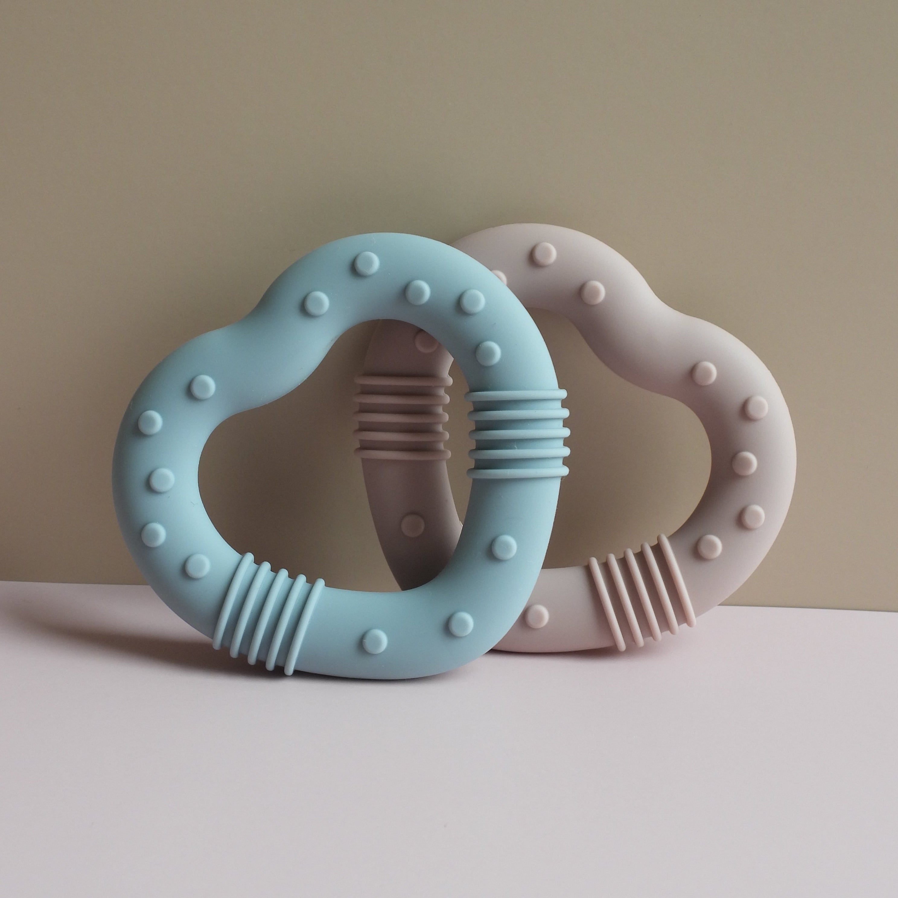 Teething ring with blue and pink colors on a neutral background