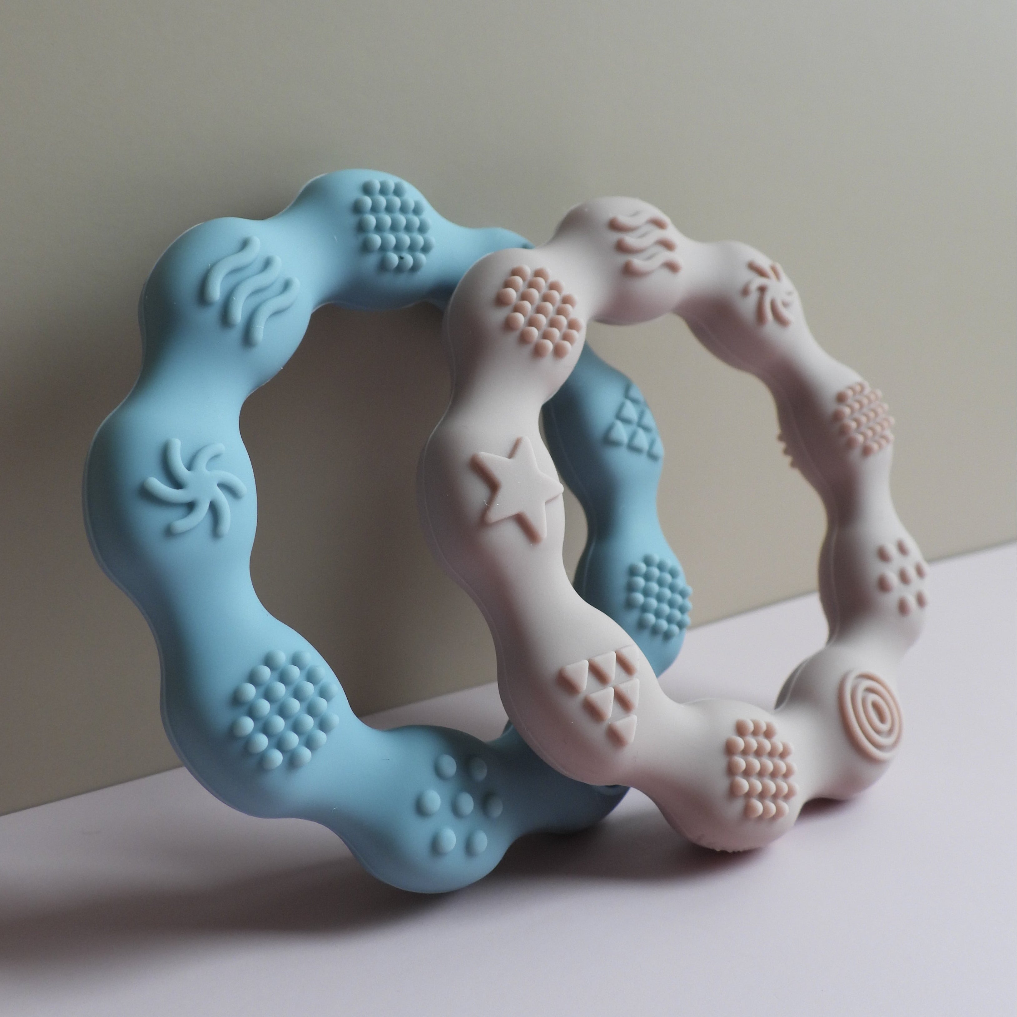 Teething ring with blue and pink colors on a light background