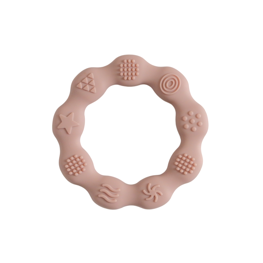 Pink silicone teething ring with various textures on a white background